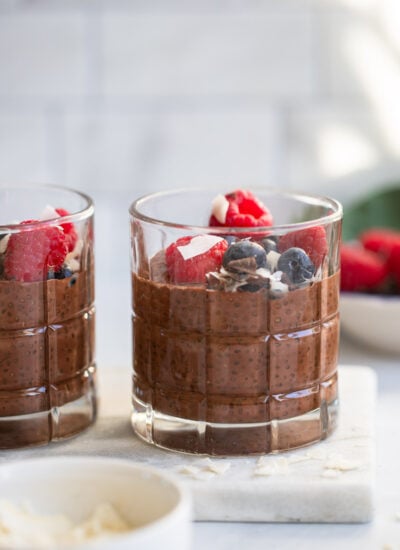 chocolate chia seed pudding in a glass garnished with fresh berries.