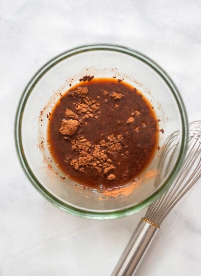 cocoa powder and hot coffee in a bowl with a whisk.