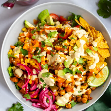 chickpea taco salad in a bowl topped with creamy cashew dressing.