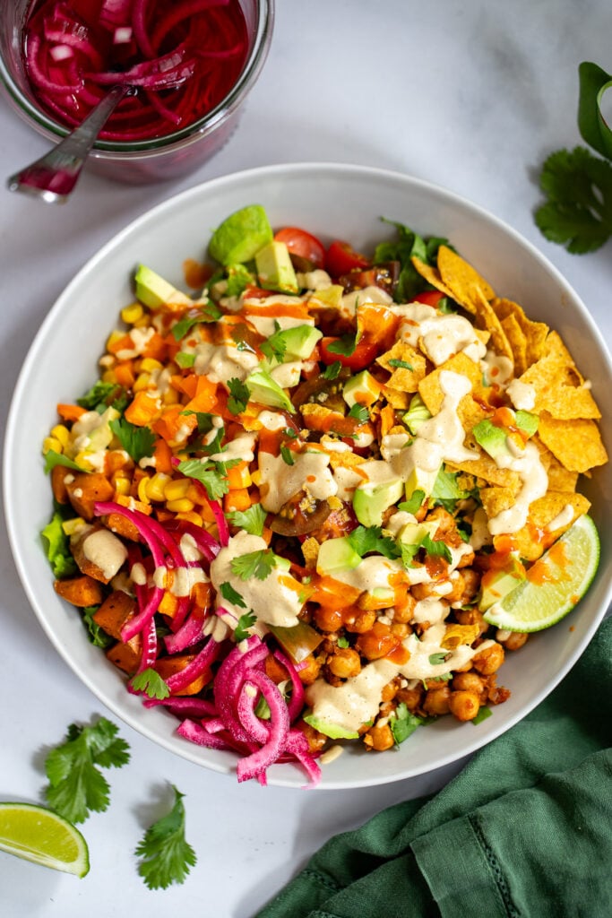 chickpea taco salad in a bowl topped with creamy dressing. 