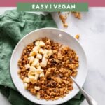 homemade peanut butter granola with chopped banana in a white bowl.