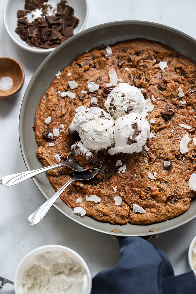 peanut butter chocolate chip skillet cookie with ice cream and 2 spoons.