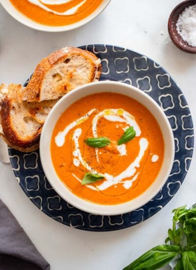 creamy vegan tomato soup garnished with fresh basil.
