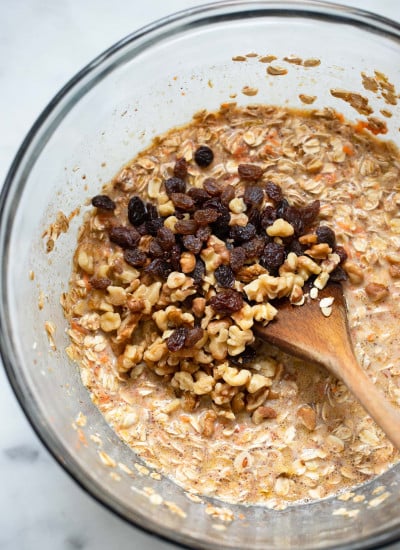 carrot cake baked oatmeal batter with walnuts and raisins on top.