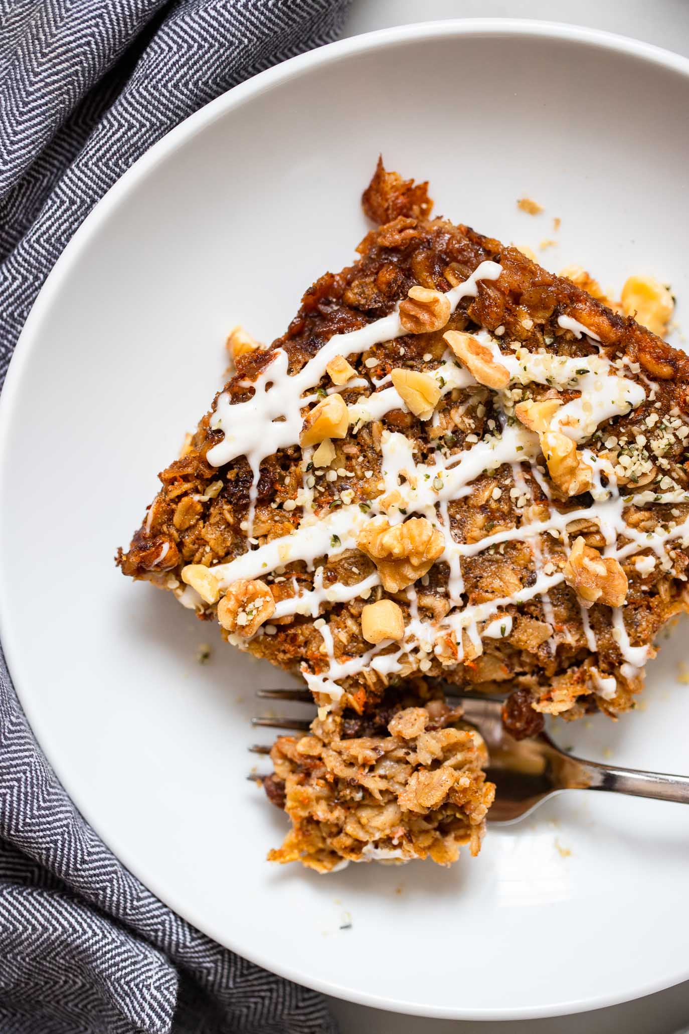 slice of carrot cake baked oatmeal in a white bowl.