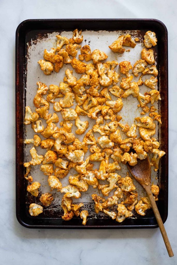 add seasoned cauliflower to sheet pan and bake