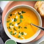 curried carrot ginger soup in bowl with fresh cilantro for garnish.