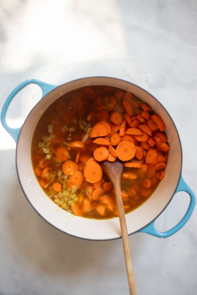 Add the spices, garlic, ginger, carrots and broth and simmer until the carrots are tender.