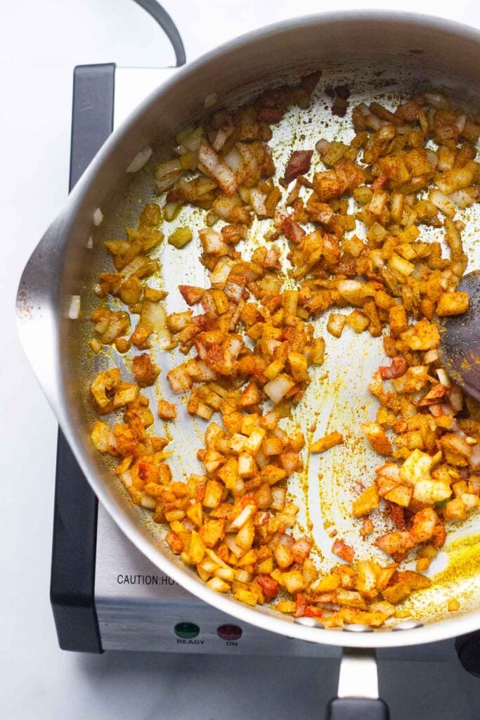 add oil, onion, paprika, and curry powder to a skillet and sauté.