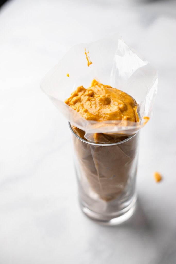 Set piping bag upright in a glass to make it easier to fill with batter.