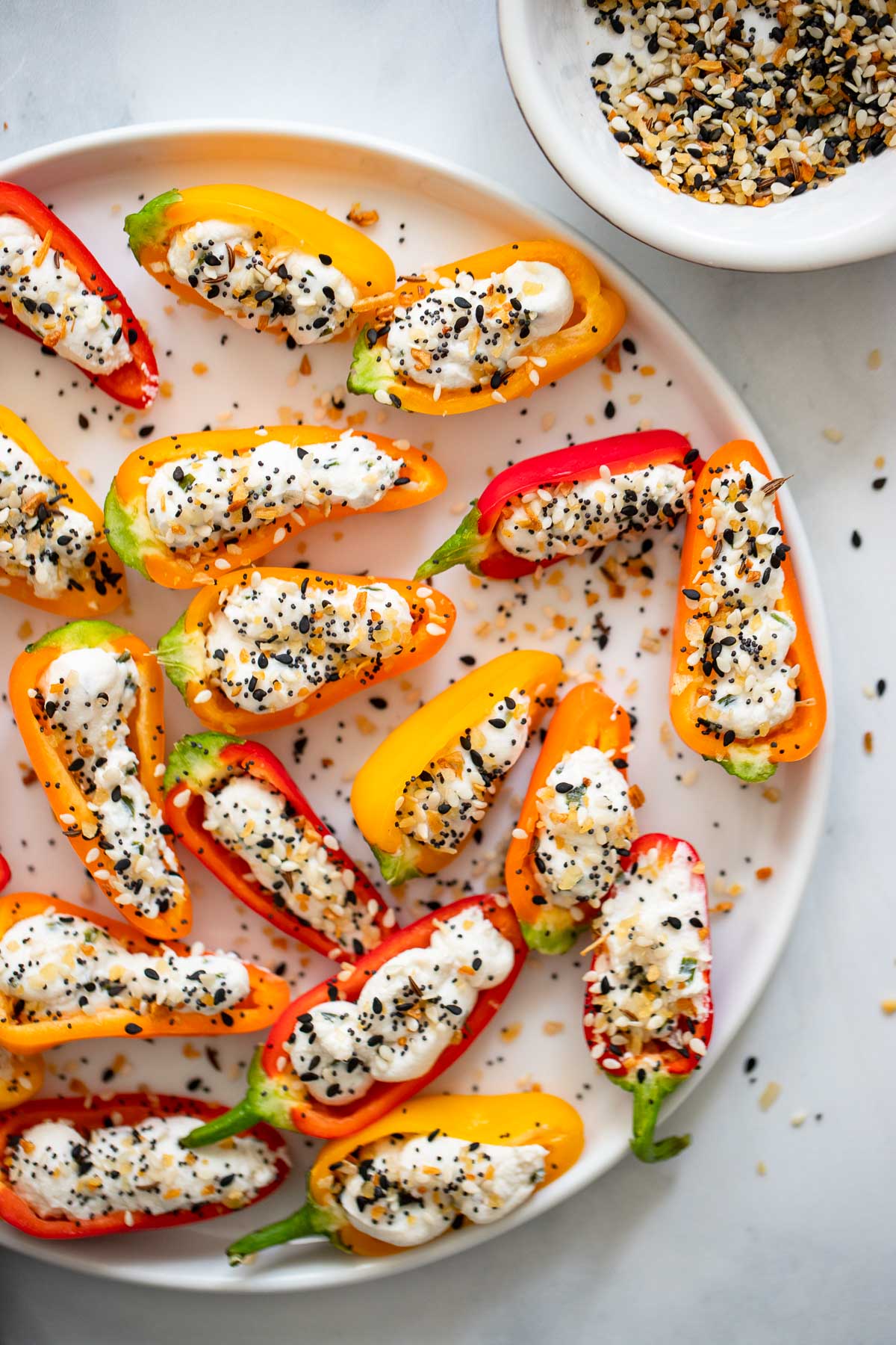 mini stuffed peppers on a plate with everything bagel seasoning.