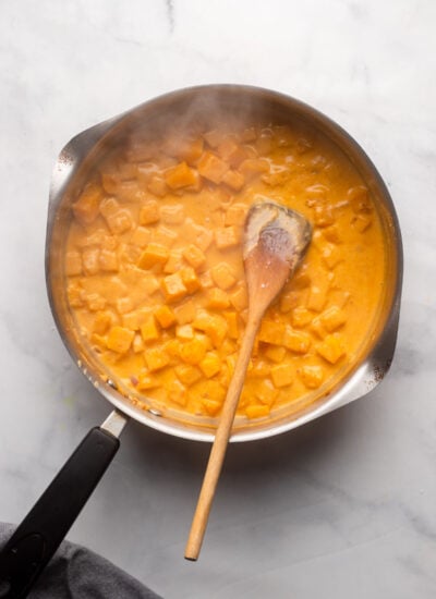 skillet with butternut squash and coconut milk added.