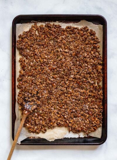 granola spread into an even layer on a parchment lined pan.