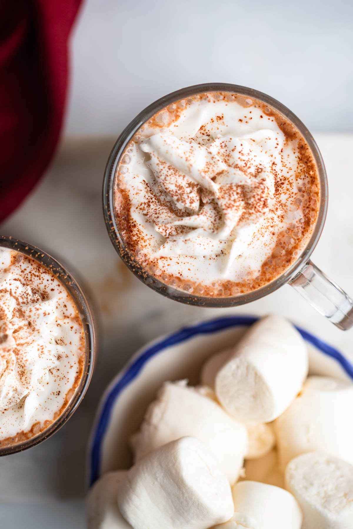 spiked vegan hot chocolate in glass mug with whipped cream.