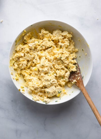 crumbled tofu in a bowl with the mayonnaise mixture stirred in.