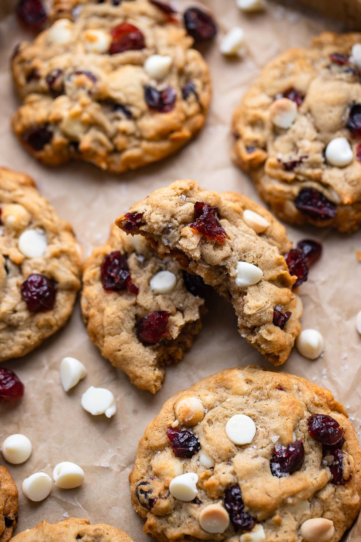 close up of one white chocolate oatmeal cookie that has been broken in half.