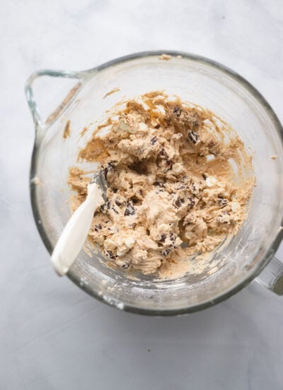 cookie dough with cranberries and white chocolate chips in mixing bowl.