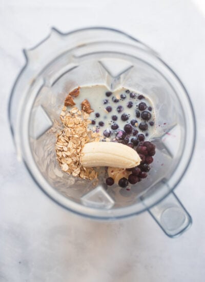 blueberry oat smoothie ingredients in blender pitcher before blending.