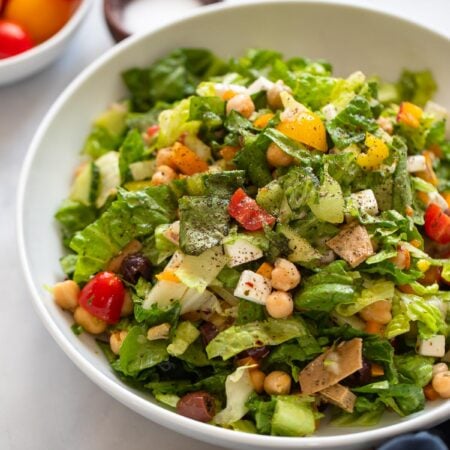 vegan Italian chopped salad in bowl with black pepper.