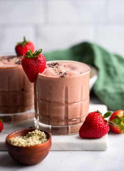 chocolate strawberry banana smoothie in glass with fresh strawberry for garnish.
