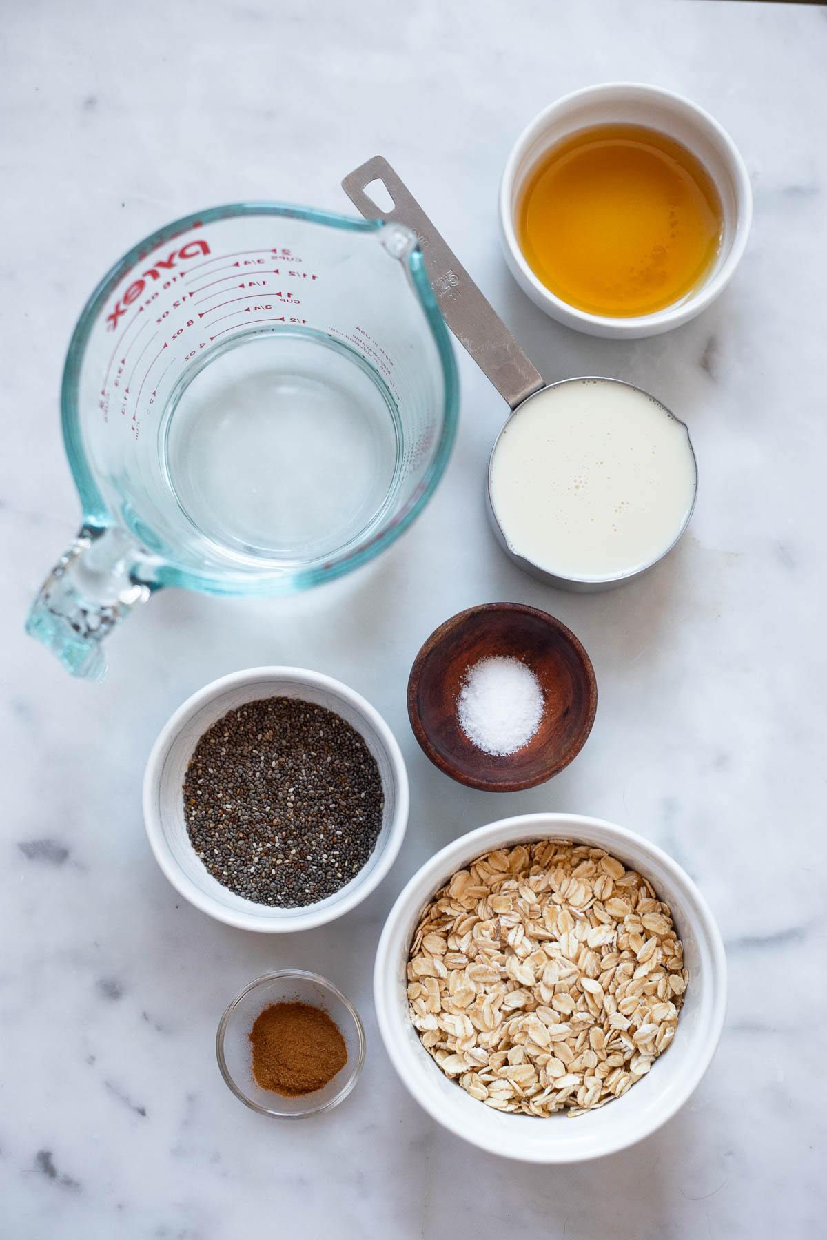 chai spice oatmeal ingredients in small bowls laid out on a table.