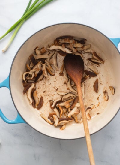 dutch oven with cooked sliced shiitake mushrooms. 