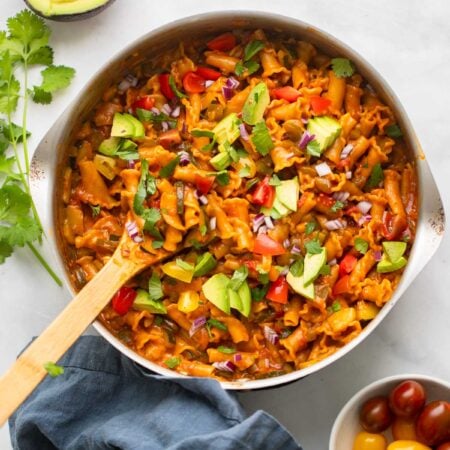 vegan taco pasta garnished with avocado and cilantro.