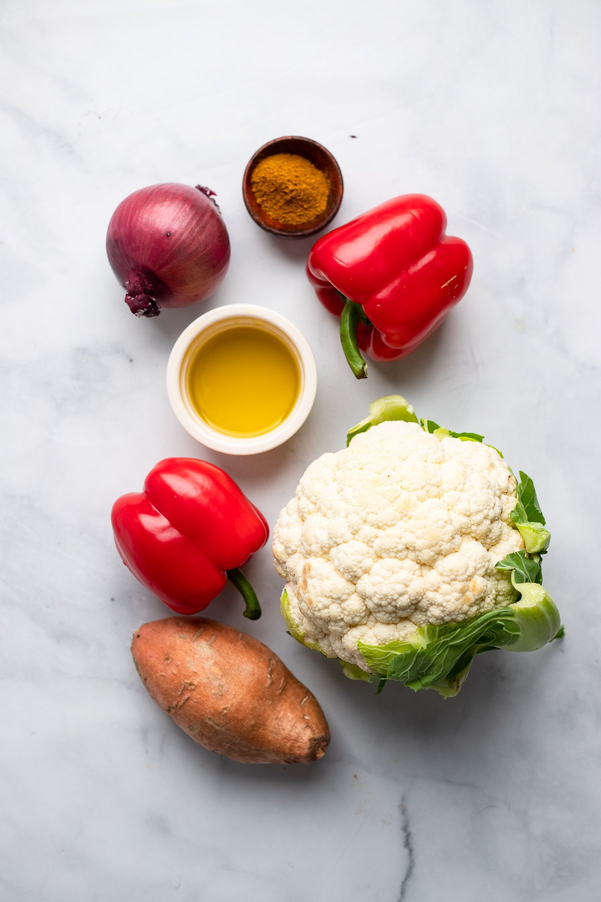 curry roasted vegetables recipe ingredients laid out on a white background. 