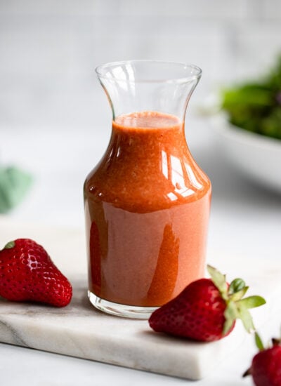 strawberry balsamic dressing in glass dressing container.