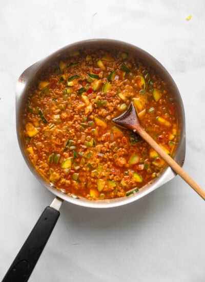skillet with cooked veggies, water, and salsa added ready to simmer. 