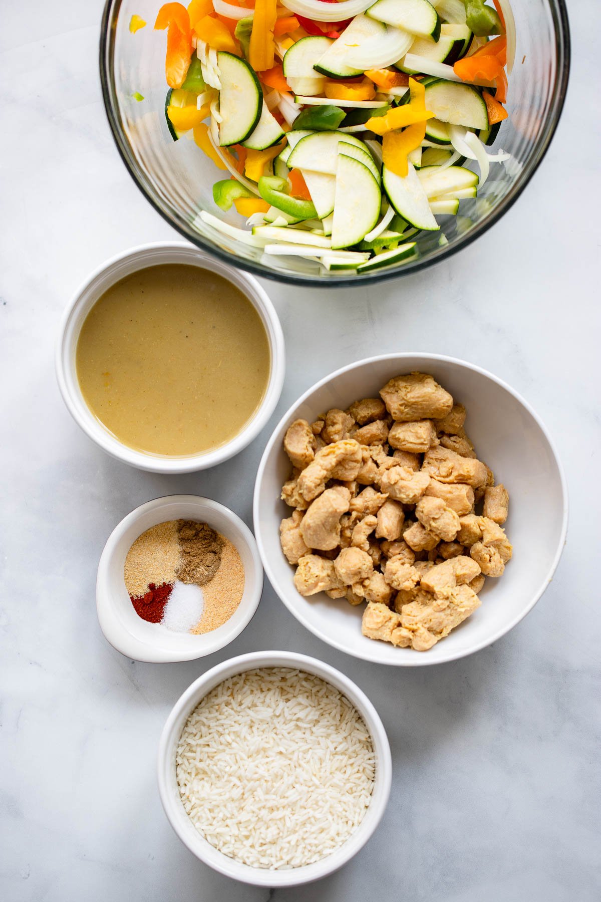 vegan tex mex bowl ingredients in bowls arranged on a white background. 