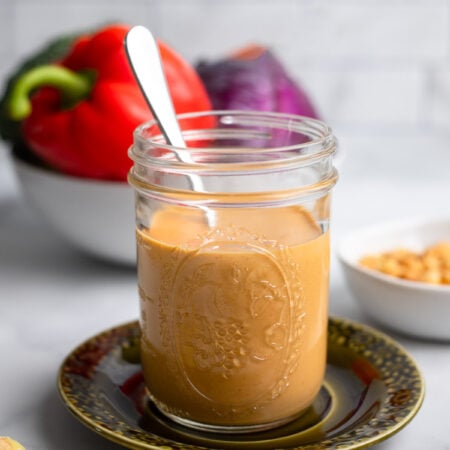 peanut butter stir fry sauce in a jar with a spoon.