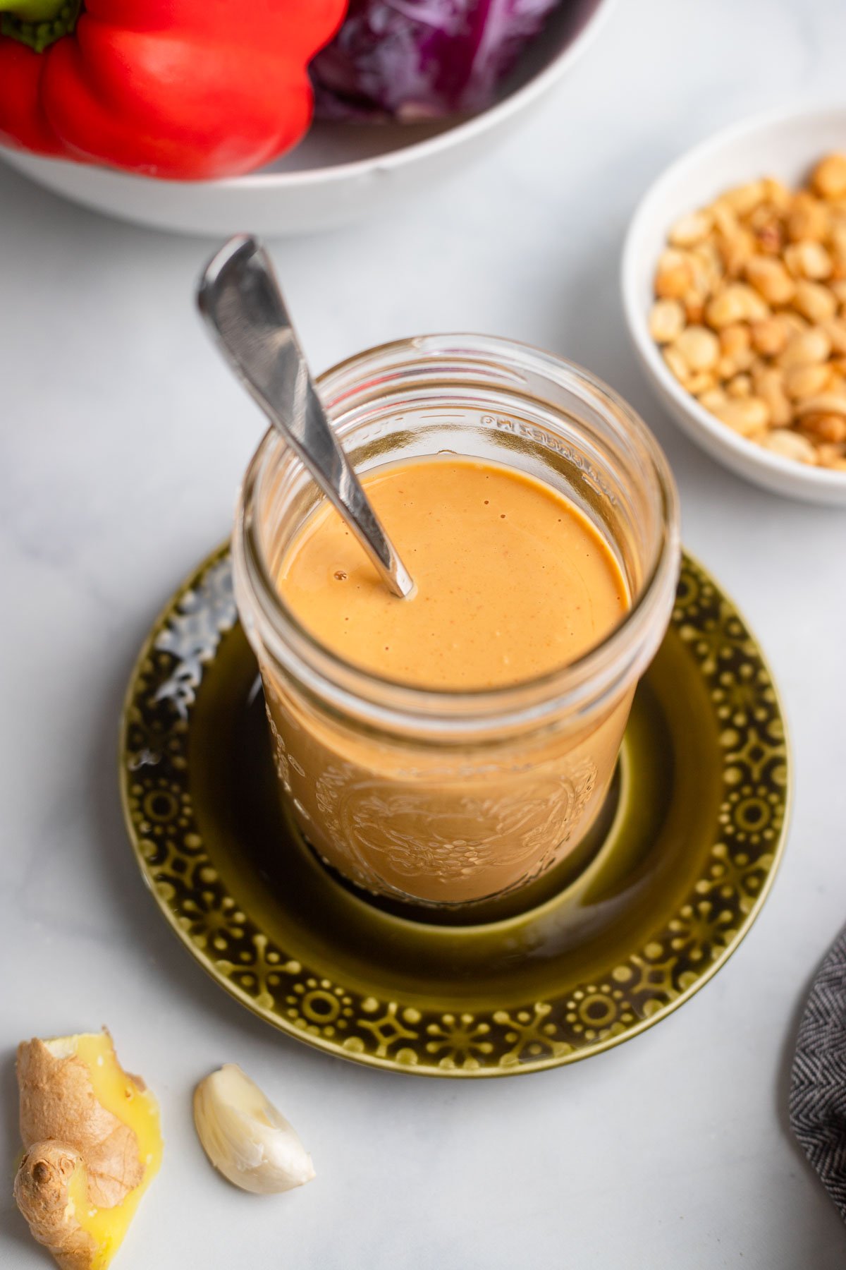 peanut butter stir fry sauce in a jar with a spoon.
