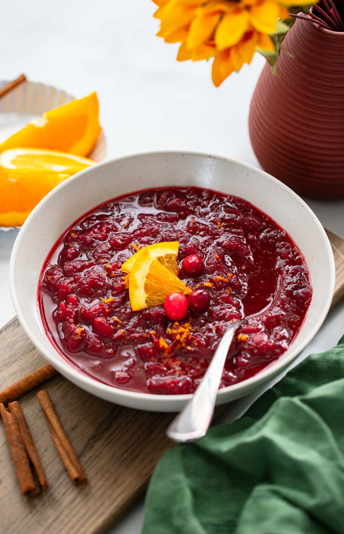 cranberry sauce in a low bowl garnished with fresh cranberries and orange slices.