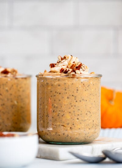 pumpkin pie overnight oats in a glass jar topped with chopped pecans.