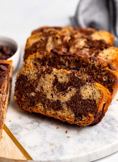 slices of marbled chocolate banana bread on a white marble board.