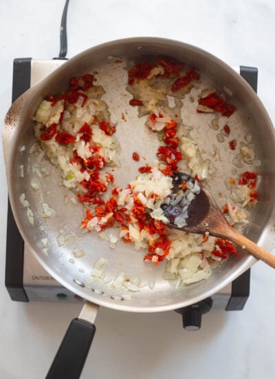 sautéed onion and sun-dried tomatoes in a skillet. 