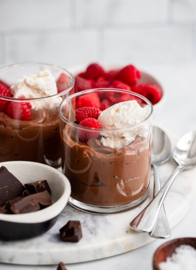 vegan chocolate mousse in a glass with whipped cream and fresh raspberries.