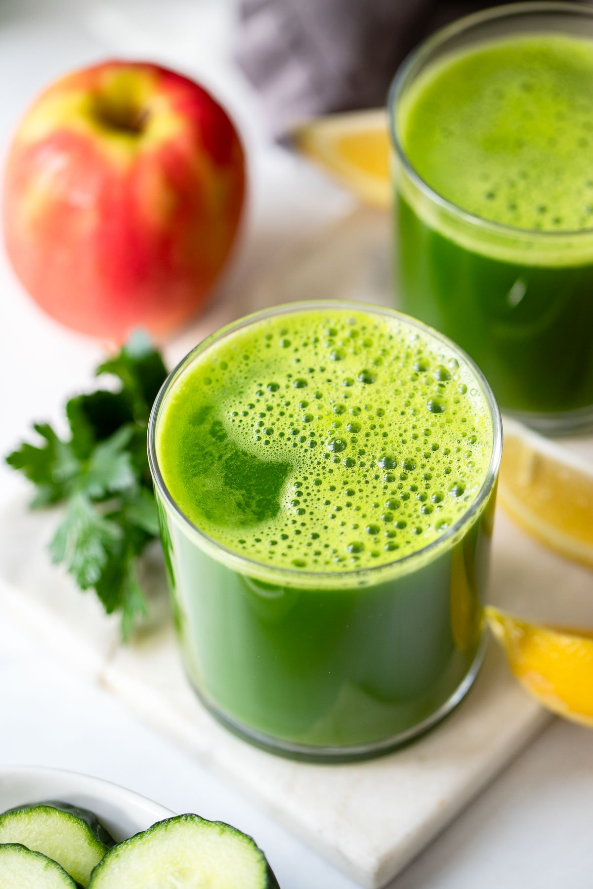 glass of green juice on a white background.
