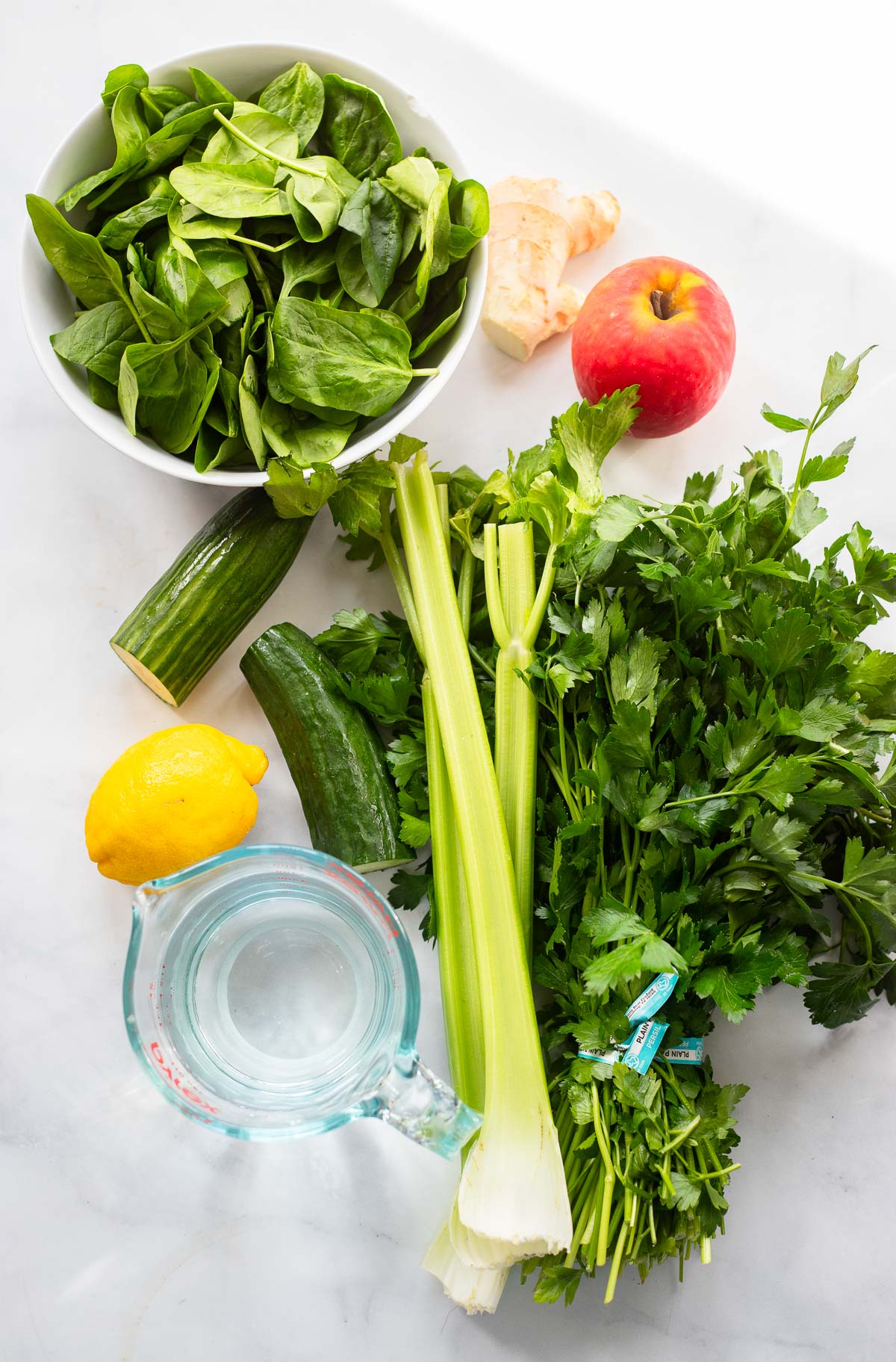 blender green juice ingredients on a white background.
