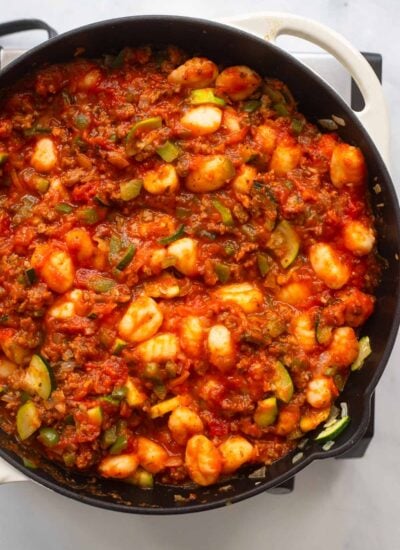 gnocchi, marinara, and vegetables cooked in a skillet. 