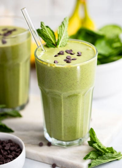 mint chocolate chip shake in a tall glass with fresh mint.
